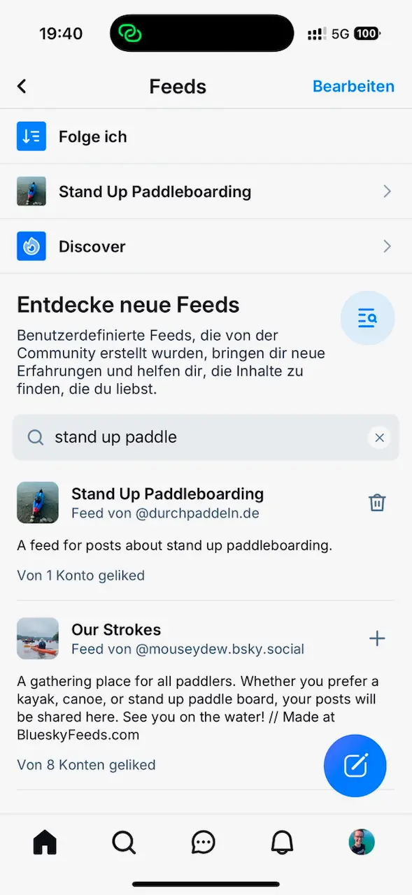 Screenshot der Bluesky-App im Bereich "Feeds". Oben sind die Optionen "Folge ich", "Stand Up Paddleboarding" und "Discover" sichtbar. Darunter ein Abschnitt "Entdecke neue Feeds" mit der Beschreibung, dass benutzerdefinierte Feeds neue Inhalte bieten. Es wird nach "stand up paddle" gesucht, und zwei Feeds werden angezeigt: "Stand Up Paddleboarding" von @durchpaddeln.de, mit einem Profilbild eines Paddlers, und "Our Strokes" von @mouseydew.bsky.social, ein allgemeiner Feed für Paddler mit einem Bild von Kajaks. Oben rechts werden Symbole für Uhrzeit, Netzwerkstatus und Akkustand angezeigt.